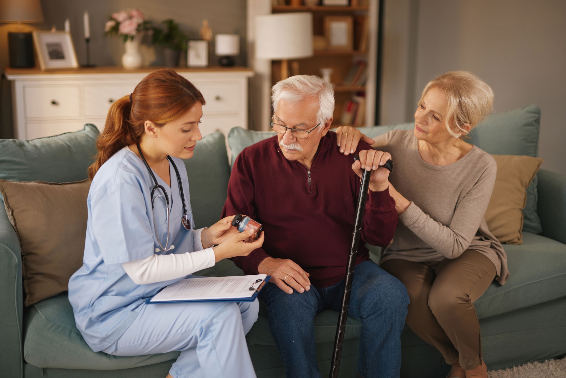 Nurse explaining medicine to senior couple at home visit